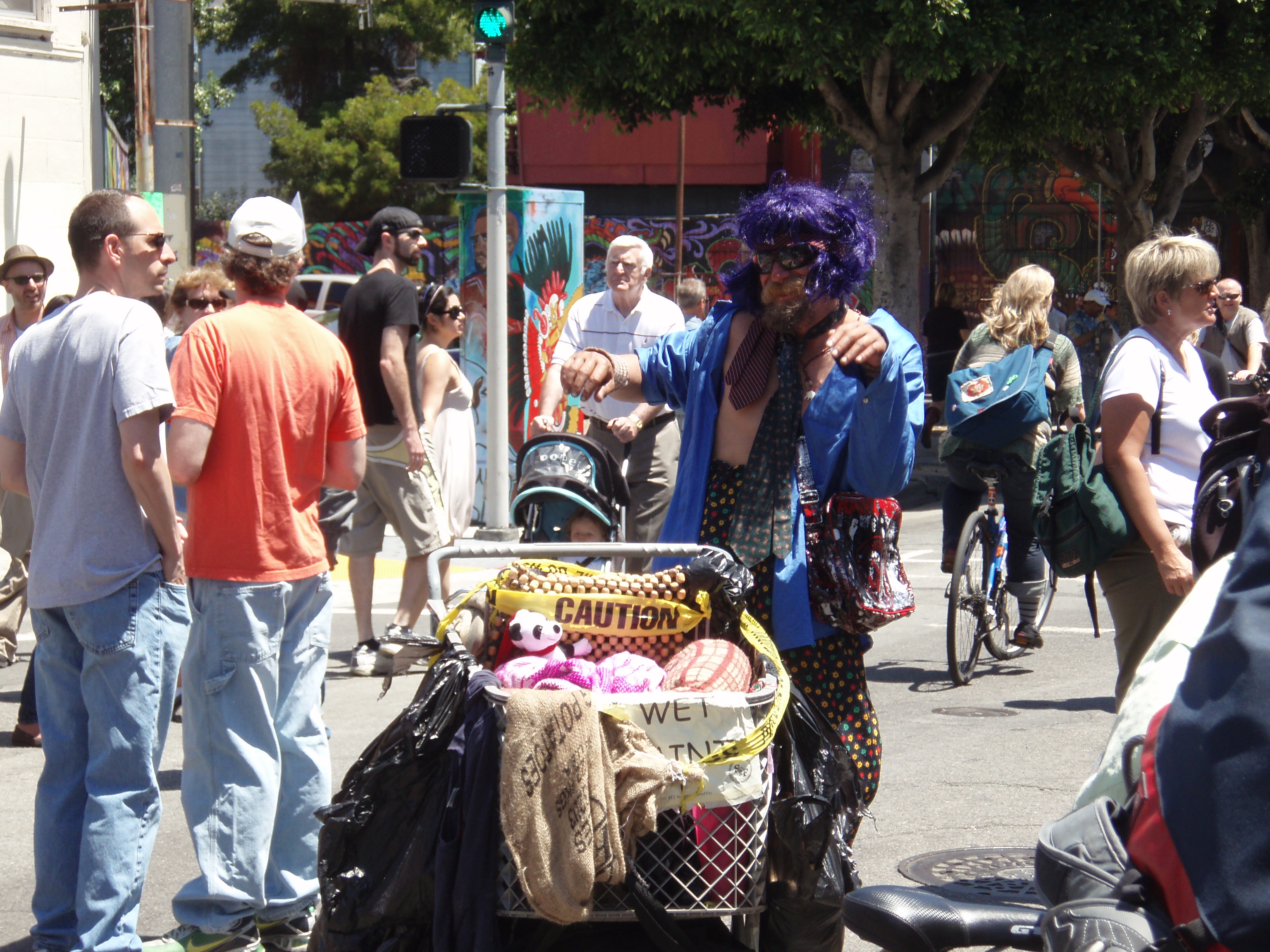 Sunday streets - homeless man jamming out It only took me 3 minutes to find my first scene. When the Aztec dance demo was going on, this <i>apparently</i> homeless man decided to start breaking it down. He danced for a solid 5 minutes. And what an outfit: purple wig, multiple ties, a plastic Rancid purse, high-waisted poka-dot pants, and a hot pair of shades. He should be on Fashionist.