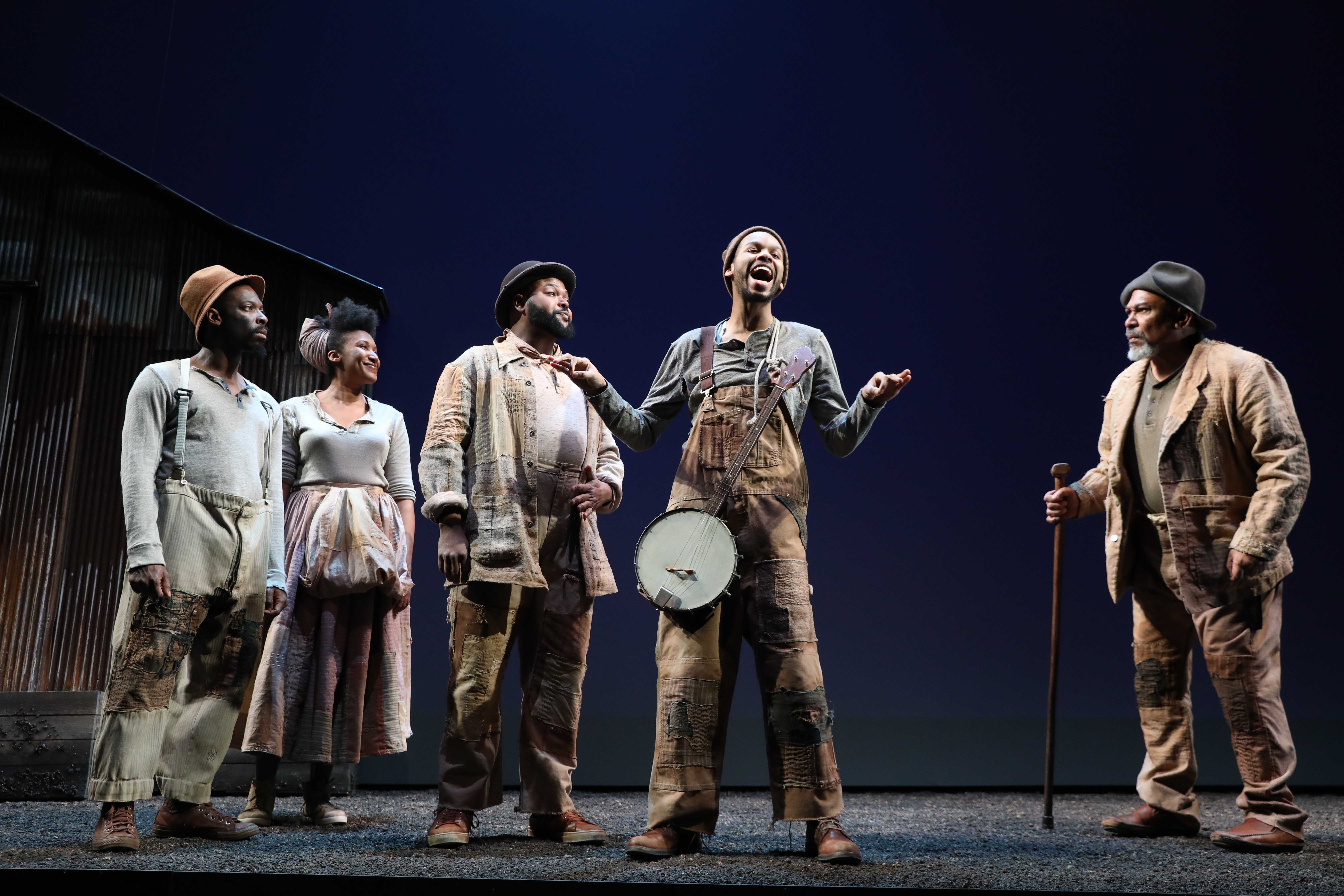 Photo by Joan Marcus. A chorus of enslaved people—Second (Rotimi Agbabiaka), Third (Safiya Fredericks), Leader (Chivas Michael), Homer (Julian Elijah Martinez) and The Oldest Old Man (Steven Anthony Jones), Hero’s surrogate father—place bets over whether Hero will accompany The Colonel to the Civil War in Suzan-Lori Parks’s Father Comes Home from the Wars (Parts 1, 2 & 3), performing at A.C.T.’s Geary Theater April 25–May 20, 2018. 